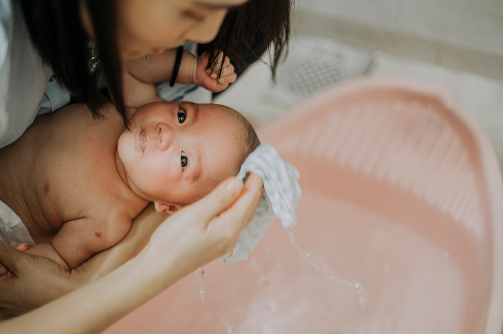 使用溫水浸濕毛巾幫寶寶擦澡，是有效降低寶寶體溫的方法